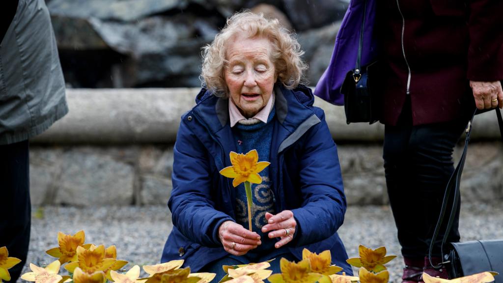 Woman with paper daffodil in Garden of Hope