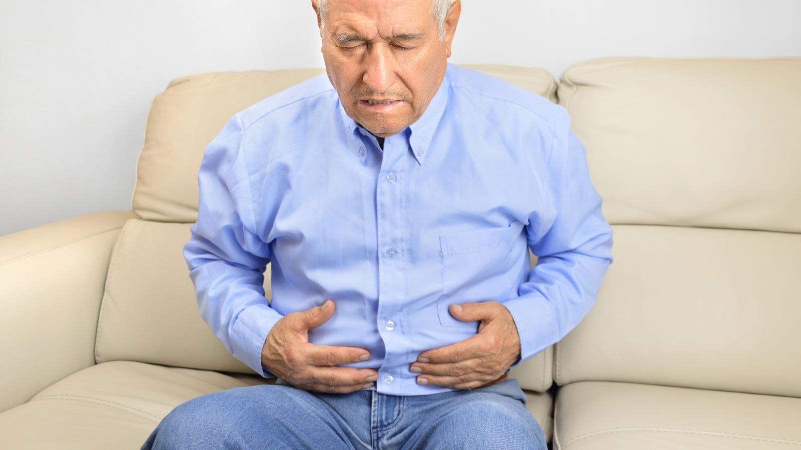 Older man holding his stomach in pain