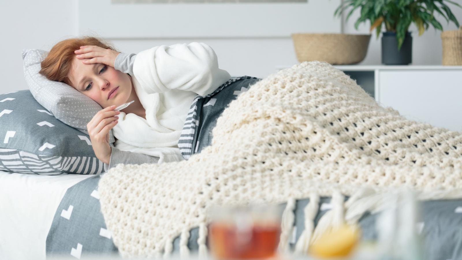Woman laying in bed feeling sick