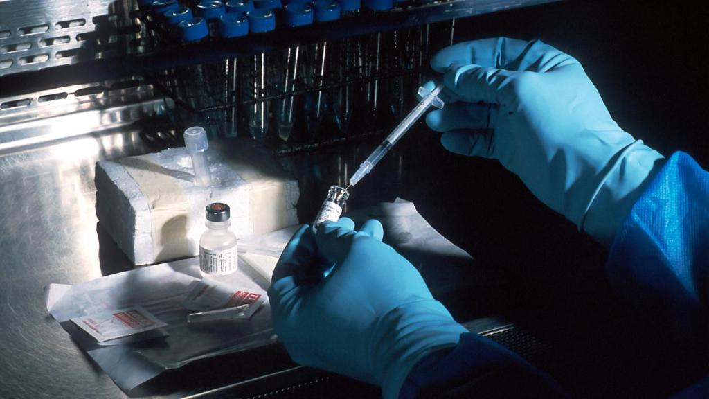 A doctor drawing liquid from a phial into a syringe