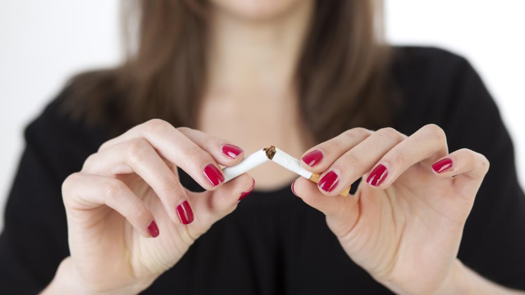 Woman breaking a cigarette in half