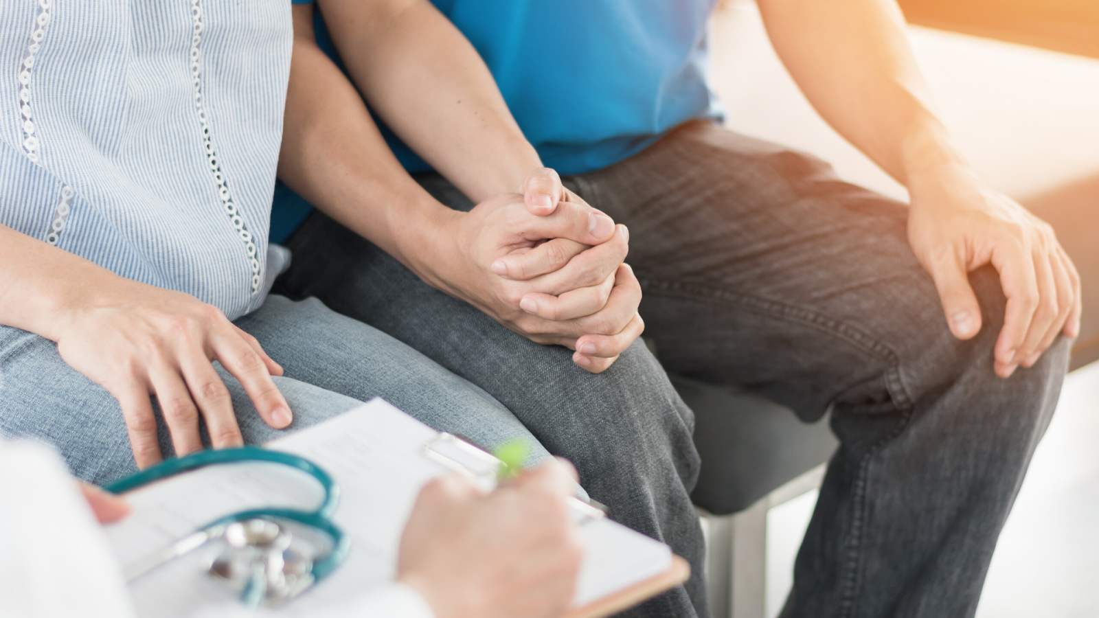 A picture of a couple holding hands in a doctor's office